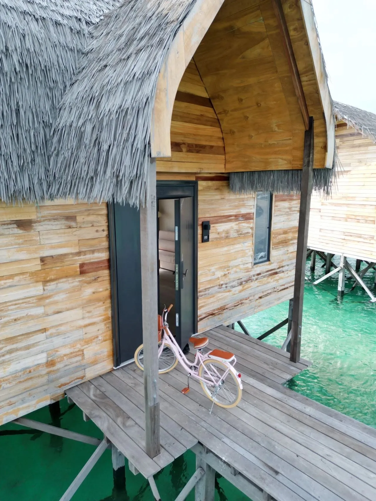 Villa entrance with a pink bicycle on the deck